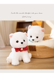 Close-up of two white Pomeranian plush toys with bowties in a woven pet basket
