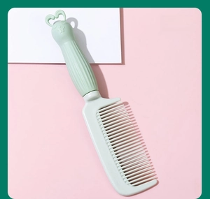 Close-up of a cute mint green rabbit handle hair comb with fine teeth for styling