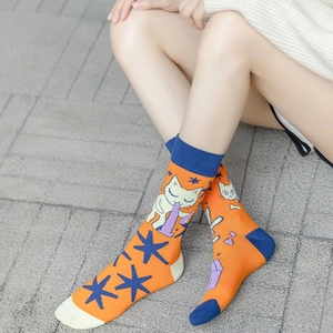 Asymmetric cotton crew socks featuring bright orange knit with cartoon cat and star patterns