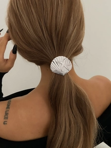 Detailed view of silver metallic shell and starfish hair accessory on low ponytail