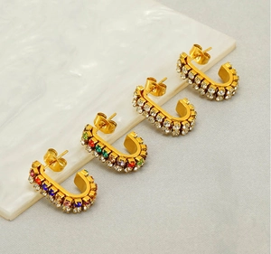 Close-up of gold C-shape hoop earrings with multicolored double-row sparkling rhinestones