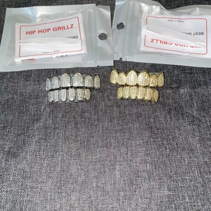 Detail view of hip hop grillz set with tweezers, instructions, and retail packaging