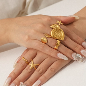 Detailed close-up of ocean-themed starfish and seashell gold adjustable ring set