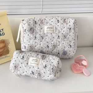 Close-up of quilted blue striped bear makeup bags with smooth zipper and soft texture