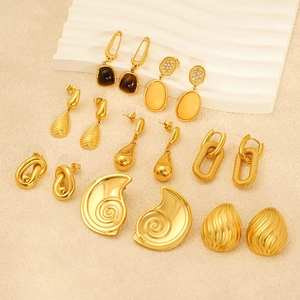 Set of eight gold textured earrings with mixed gemstones on elegant wave display stand