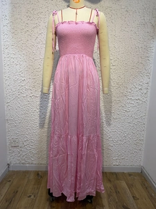Detail of pink spaghetti strap maxi dress with pleated bodice and tiered ruffle skirt