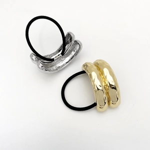 Golden and silver U-shaped metal hair ties with irregular pleated texture on white background