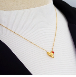 Détail du collier cœur plaqué or 18K avec émail rouge et diamants sur un mannequin