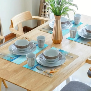 Close-up of rectangular beach shell placemats with blue ocean pattern on wood table