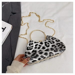 Detail of evening clutch featuring black and white leopard print and gold ring handle