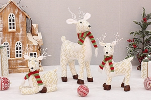 Detailed view of cream fabric reindeer Christmas ornaments with red and green scarves