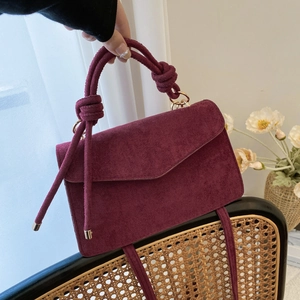 Chic burgundy suede handbag with knotted handle and elegant metal buckle design