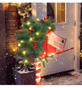 Detail of Christmas mailbox decoration with warm LED lights, pine cones and red berries
