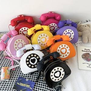 Macro view of retro telephone-shaped crossbody bags in multiple vibrant colors and textures