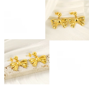 Macro shot of gold bow drop earrings with polished surface and smooth texture