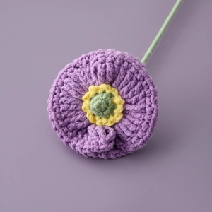 Detailed close-up of a handmade crochet purple poppy flower with intricate knit texture