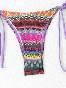 Detail of bohemian crochet bikini bottom with multi-color geometric patterns and purple side ties