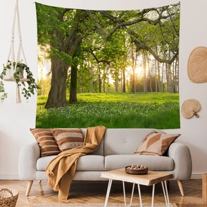 Modern forest wall tapestry hanging above a grey sofa in a cozy boho living room