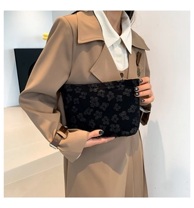 Detail shot of the embossed cloud pattern on a soft black minimalist handbag