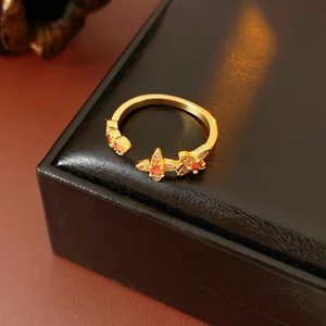 Nahaufnahme des goldenen Vintage-Schmetterlingsrings mit orangeroten Steinen