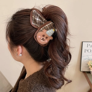 Detail of brown plaid hair claw clip with felt bear decoration on a ponytail