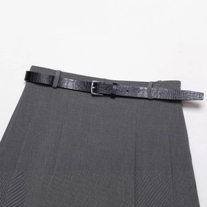 Dark grey pleated skirt with a black crocodile texture belt in a stylish flat lay view