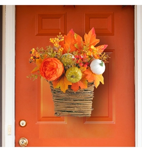 Close-up of autumn door basket with orange peonies, fall leaves and colorful pumpkins