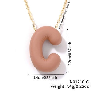 Detail of matte pink letter C pendant on gold chain with dimensions 2.2x1.4 cm