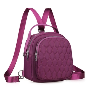 Quilted nylon mini backpack in magenta featuring a front zipper pocket and silver hardware