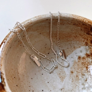 Dettaglio di collane luccicanti in argento sterling S925 su una ciotola in ceramica