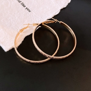 Minimalistische goldene Creolen mit mattierter Oberfläche und geometrischem Design
