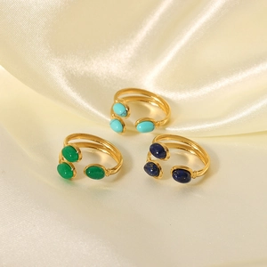 Detailed view of three gold-plated open rings with turquoise, agate, and lapis stones