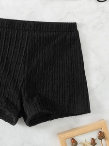 Close-up of black ribbed knit high-waisted shorts with breathable hollow-out details