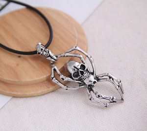 Macro detail of gothic skull spider pendant in silver metal on black rope cord