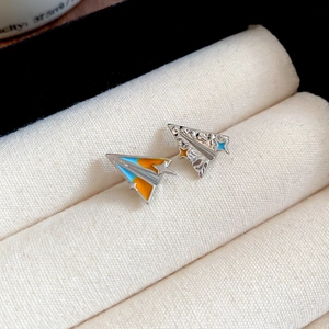 Vue macro de boucles d'oreilles avion en argent avec détails d'étoiles en émail coloré