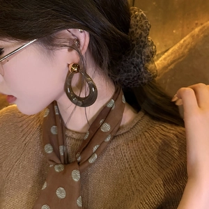 Vintage dark brown resin hollow drop earrings with golden stud on elegant female model