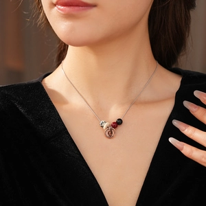 Detail of bohemian necklace with spotted stones and bronze pendant on a model's collarbone