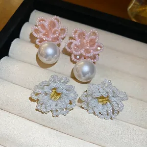 Elegant floral beaded stud earrings with white pearls in a jewelry display box