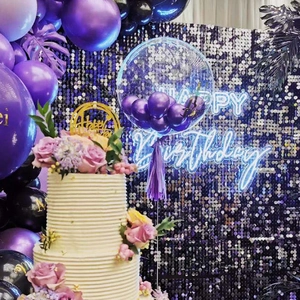 Purple wind-driven shimmer wall backdrop with neon signs and balloons for birthday parties
