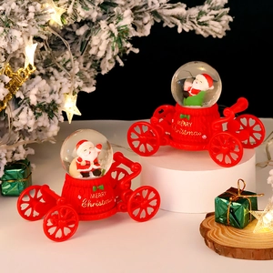 Detail of red Christmas carriage crystal ball featuring Santa Claus and festive decor