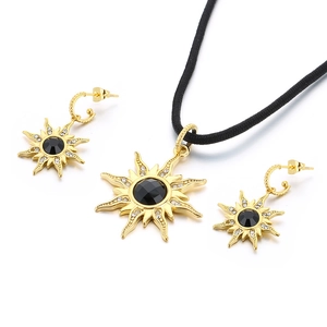 Parure bijoux soleil dorée avec pierres noires et cristaux étincelants sur cordon