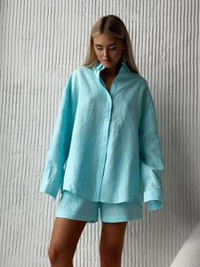 Close-up of light blue linen-blend fabric texture on a casual shirt and shorts set