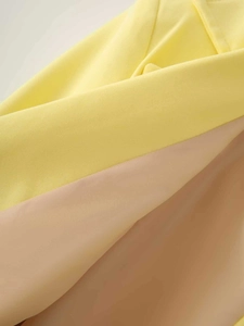 Detailed macro shot of bright yellow twill fabric and smooth beige lining of the blazer