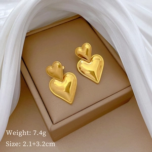 Polished gold double heart earrings in jewelry box with size and weight specs