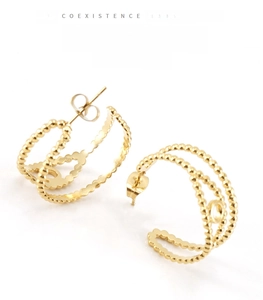 Détail de boucles d'oreilles en C ajourées avec texture perlée dorée et fermoir papillon