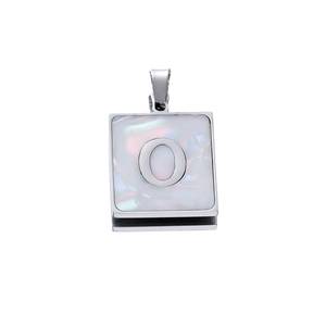 Macro detail of square stainless steel pendant with iridescent shell inlay and letter O