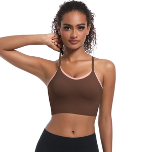 Detail of cross-back yoga bra with coffee brown body and pink trim on soft fabric
