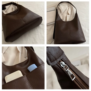 Detail of dark brown tote bag showing textured faux leather and silver metal zipper