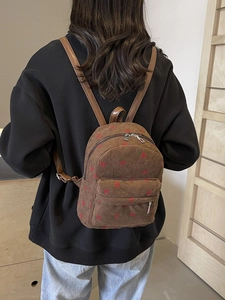 Brown corduroy backpack with red cherry pattern and adjustable leather straps for women