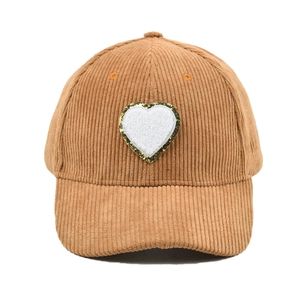 Detail einer Cord-Basecap in Camel mit Herz-Patch und goldenem Glitzer-Rand